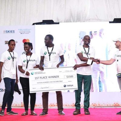 Team receives large 1st place winner cheque on stage at a youth innovation event.