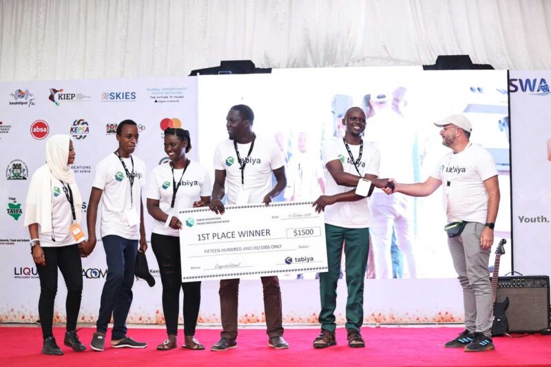 Team receives large 1st place winner cheque on stage at a youth innovation event.