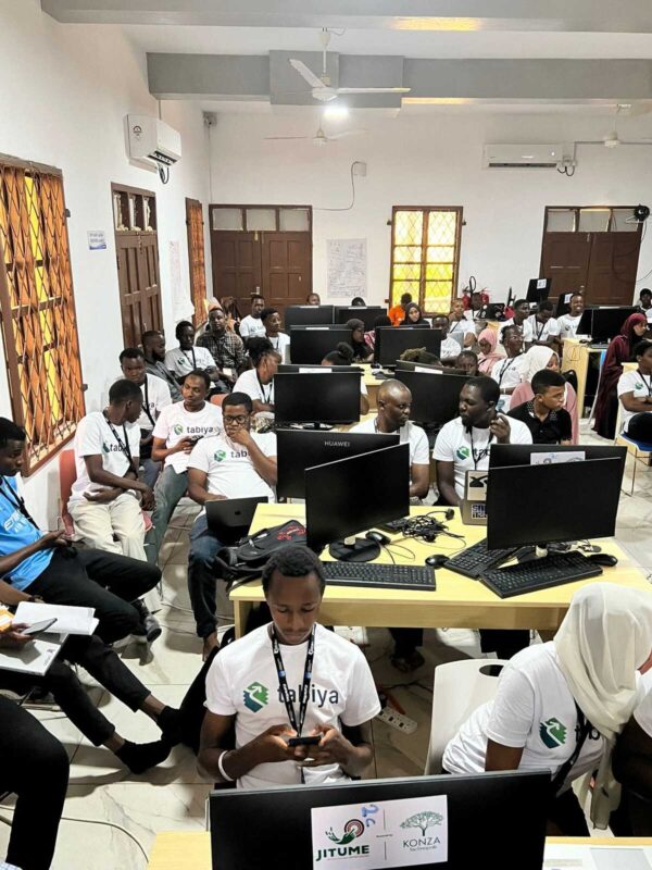 Classroom filled with students working on computers during a digital training session.